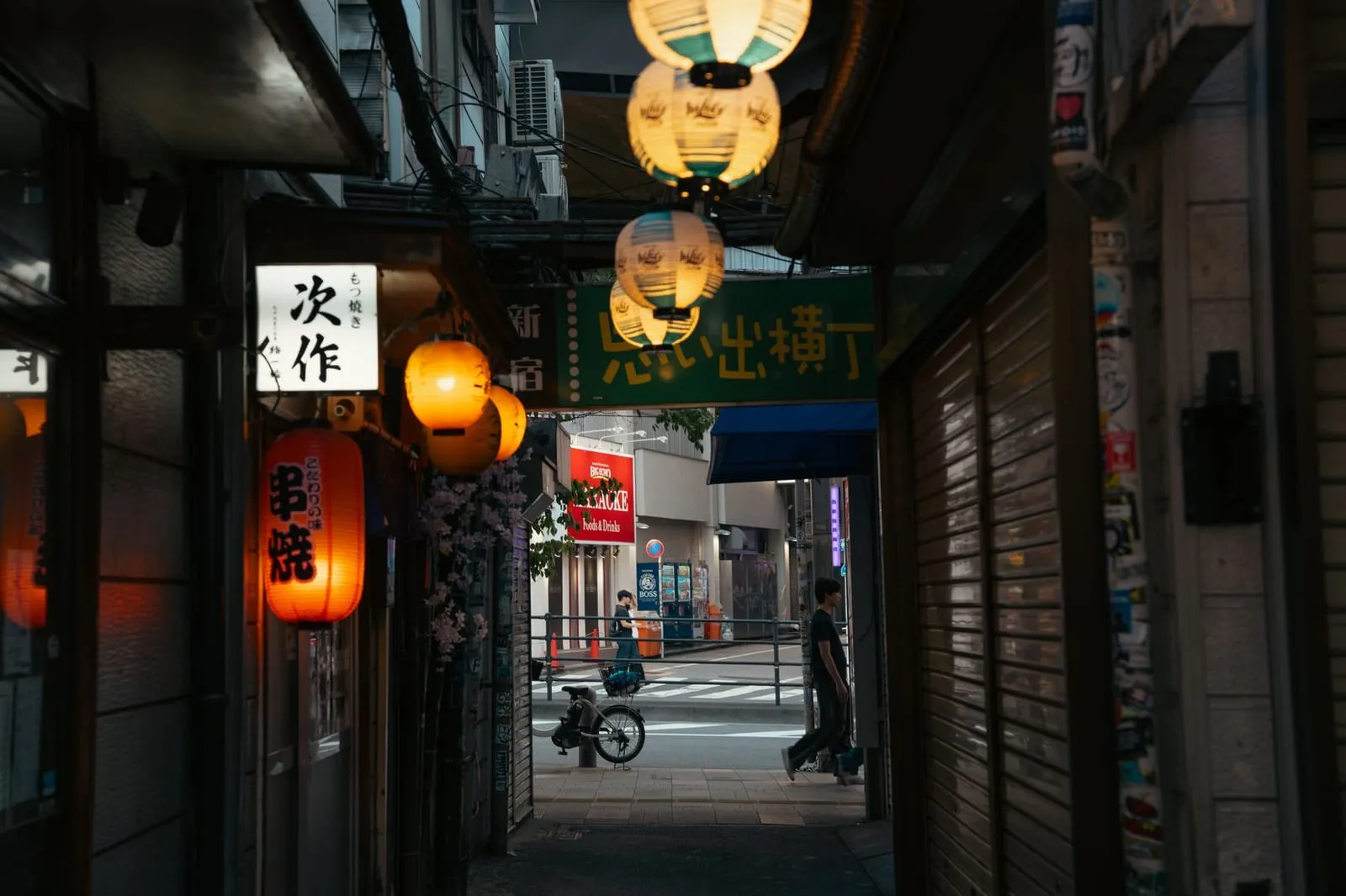 A quiet city street lined with lanterns and traditional architecture at dusk.