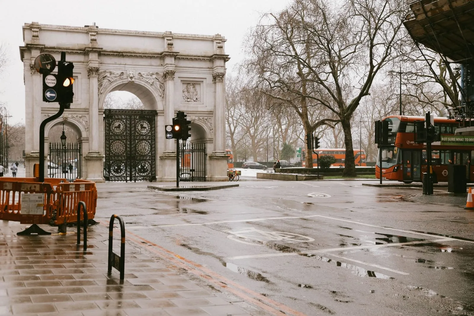 Rainy evening street scene in London with vibrant lights and classic architecture.