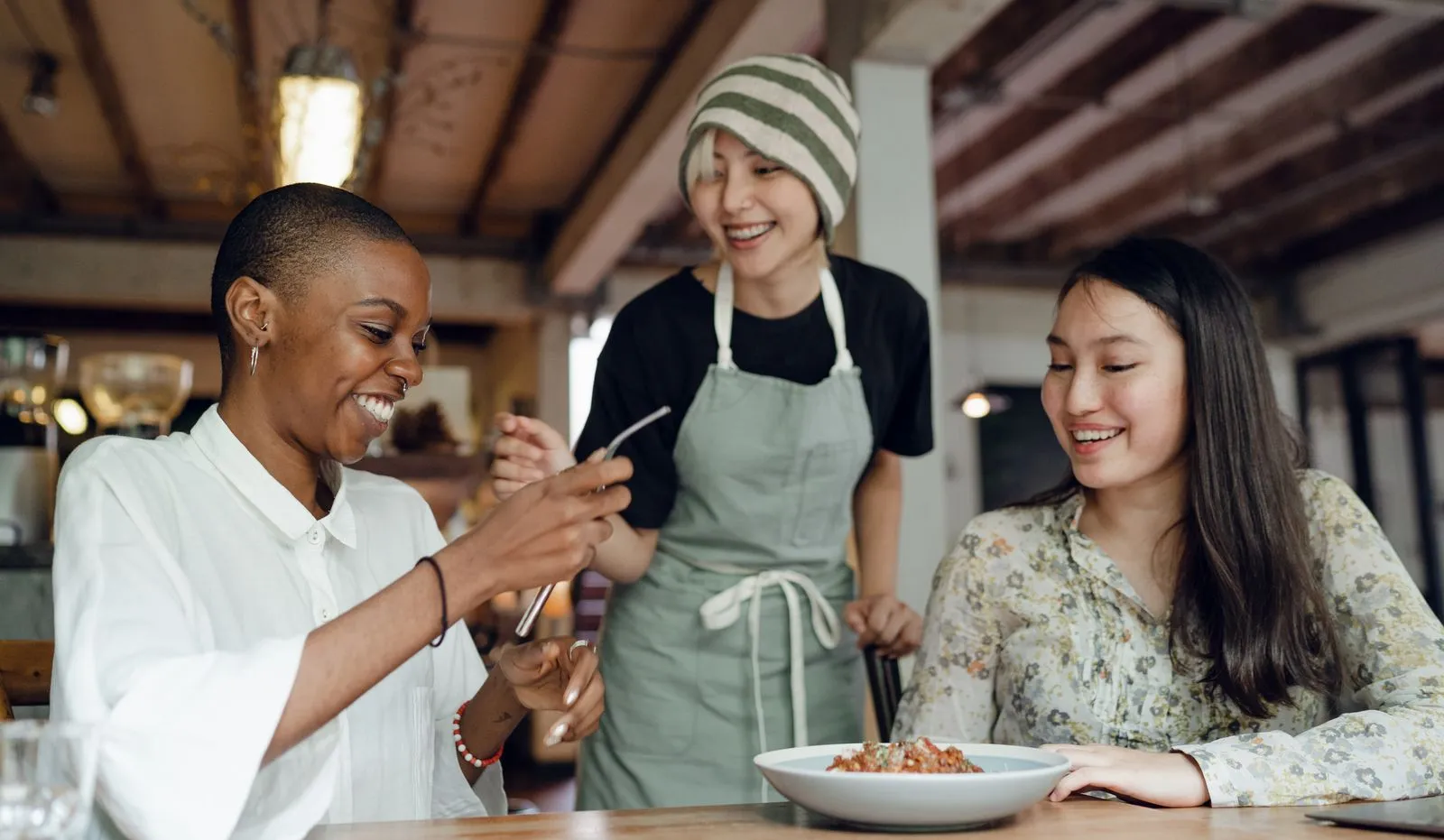 Asian friends laughing over lunch at a cafe