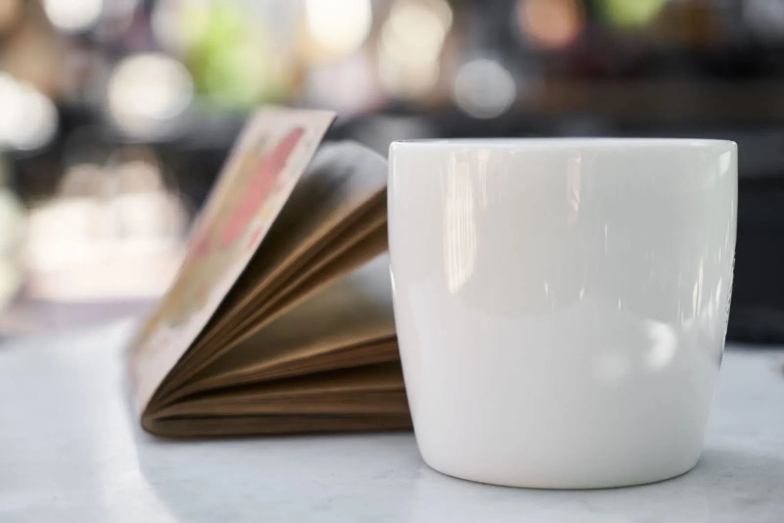 A quiet café scene with a journal and tea on the table, symbolizing reflection and recharge.